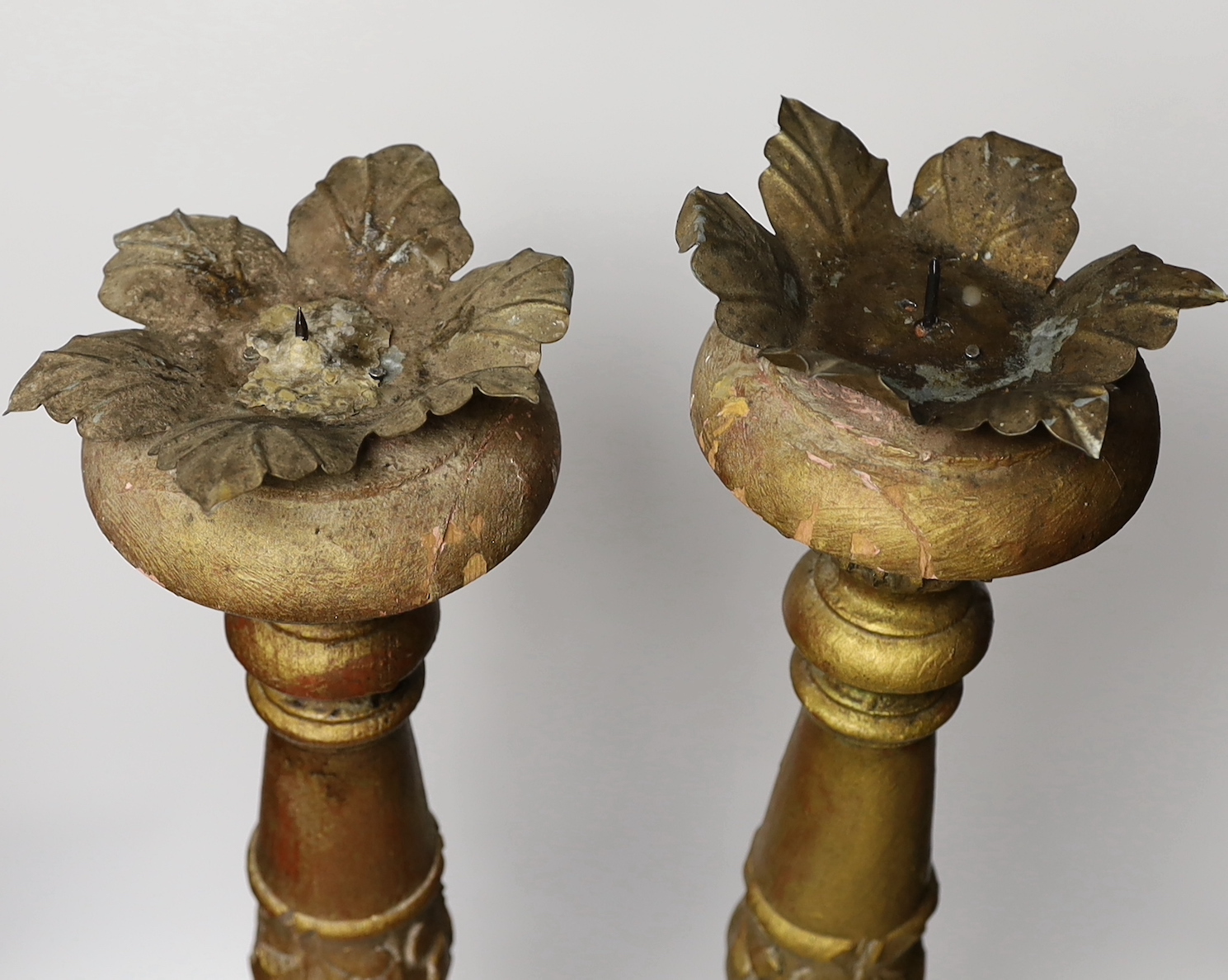 A pair of gilt and carved wooden altar sticks, 71cm